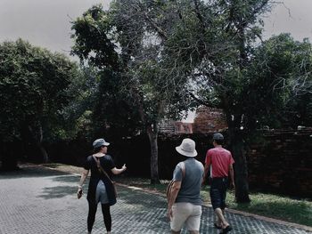 Rear view of people walking on tree