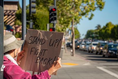 Man holding paper with text on street