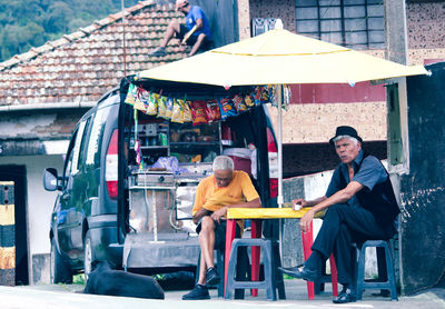 People sitting at market stall