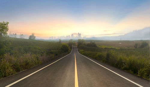 Empty road against sky during sunset