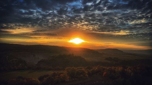 Scenic view of landscape against orange sky