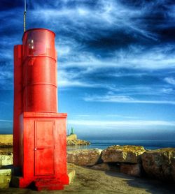 Lighthouse on sea against sky
