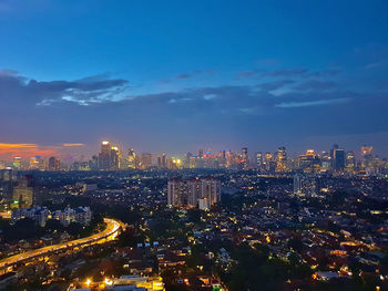 High angle view of illuminated city against sky at night