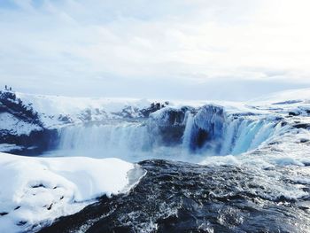 Scenic view of waterfall against sky during winter