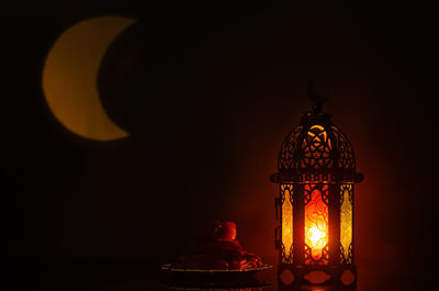 Lantern and small plate of dates fruit with moon shape from light  for holy month of ramadan kareem.