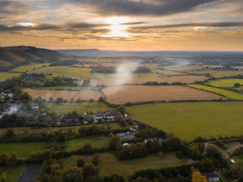 Scenic view of agricultural field against sky during sunset