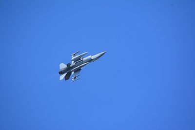 Low angle view of airplane against clear blue sky