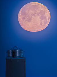 Low angle view of moon against blue sky at night