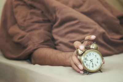 Low section of man with clock