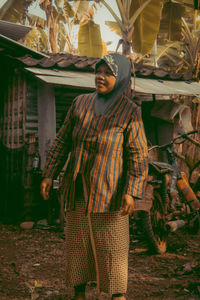 Portrait of woman standing against wall