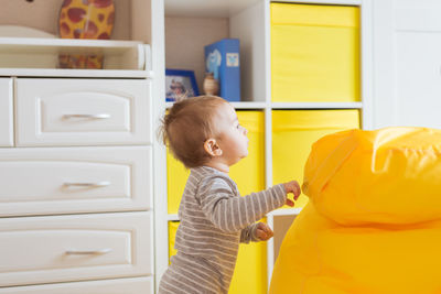 Side view of boy looking at camera at home