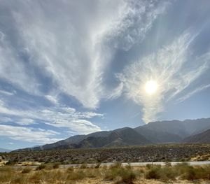 Scenic view of field and mountains against sky