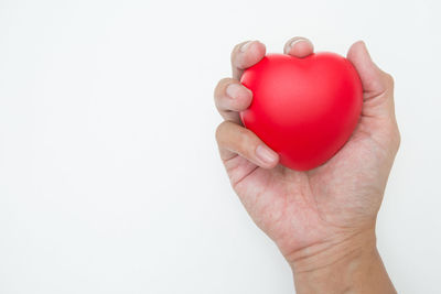 Close-up of human hand holding red background