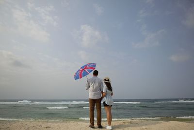 Rear view of couple standing on beach