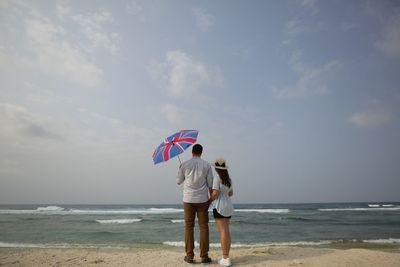 Rear view of couple standing on beach