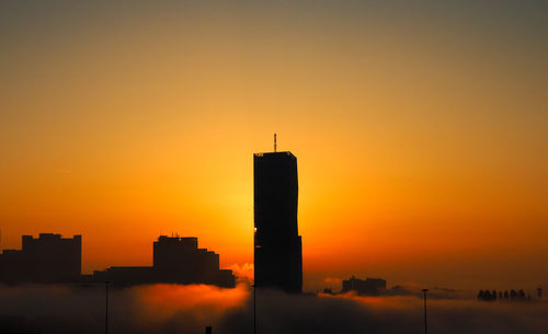 Silhouette buildings against sky during sunset