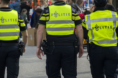 Rear view of police force standing on street