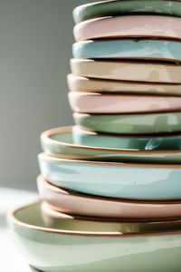 A large stack of ceramic cups in pastel colors.