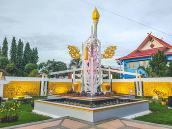 Statue by trees against sky