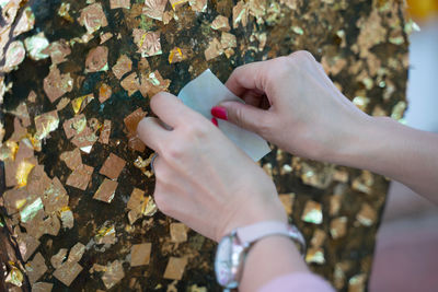 High angle view of woman hand holding paper outdoors