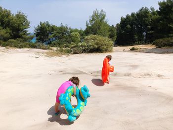 Siblings with inflatable rings at beach