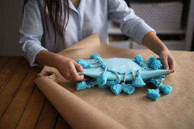 Woman packs a handicraft thing into craft paper, a small business and customer care.