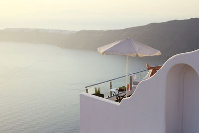 Parasol on balcony by sea during sunset