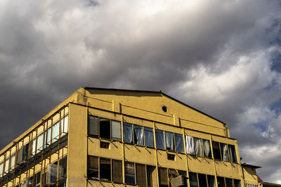 Low angle view of building against cloudy sky