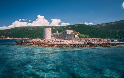 Scenic view of sea by buildings against sky