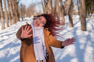 Fat caucasian woman dancing on a walk in the park in winter