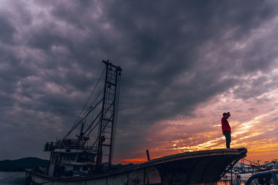 Low angle view of man against sky at sunset