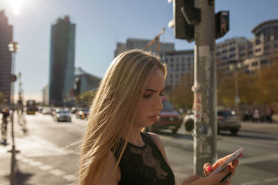 Woman using smart phone in city