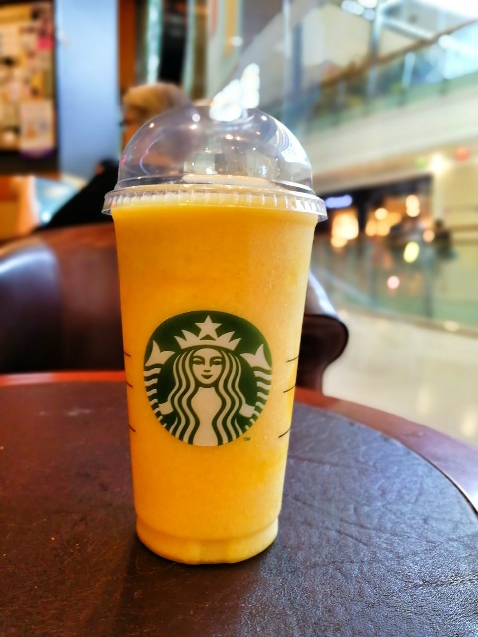 CLOSE-UP OF YELLOW DRINK ON TABLE