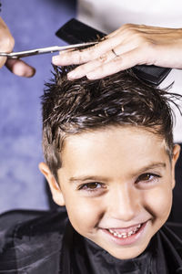 Close-up portrait of smiling getting haircut