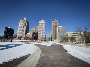 Modern buildings in city against clear blue sky