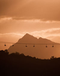 Scenic view of silhouette mountain against orange sky