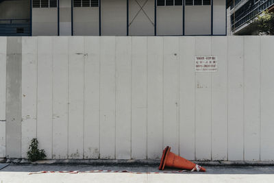 Traffic cone on road against wall