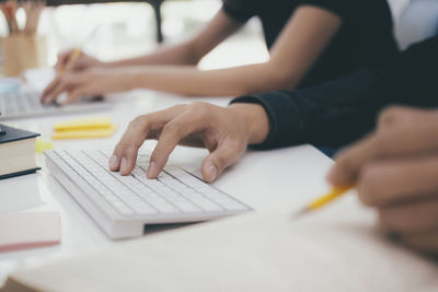 Cropped image of computer programmer working with colleague while sitting at office