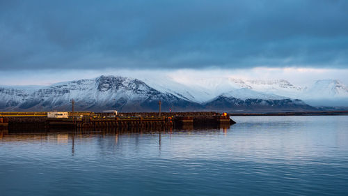 Scenic view of lake by mountains against sky