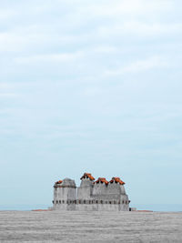 Built structure on beach against sky