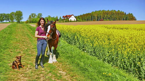 Rear view of woman with dog on field