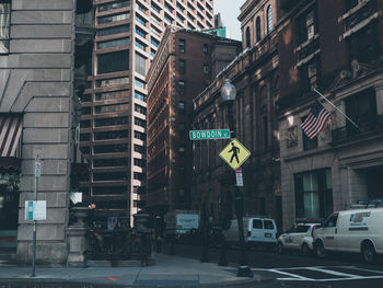 Road sign on street amidst buildings in city