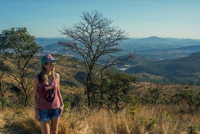 Silhouette of woman standing on mountain against sky