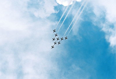 Low angle view of airshow against sky