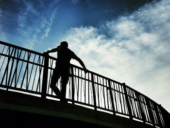 Low angle view of people standing on railing