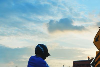 Rear view of man looking away against sky