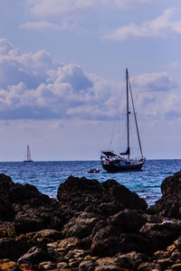 Sailboat sailing on sea against sky