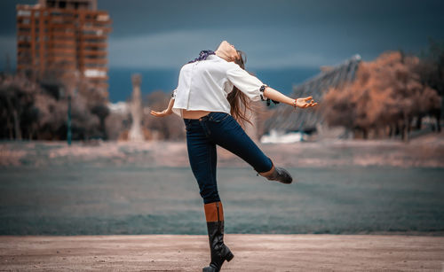 Full length of woman jumping on land