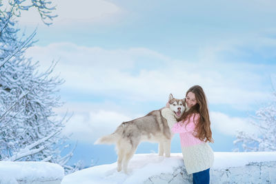 Full length of a dog on snow covered field