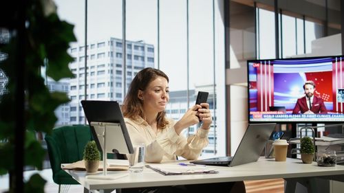 Businesswoman using mobile phone in cafe